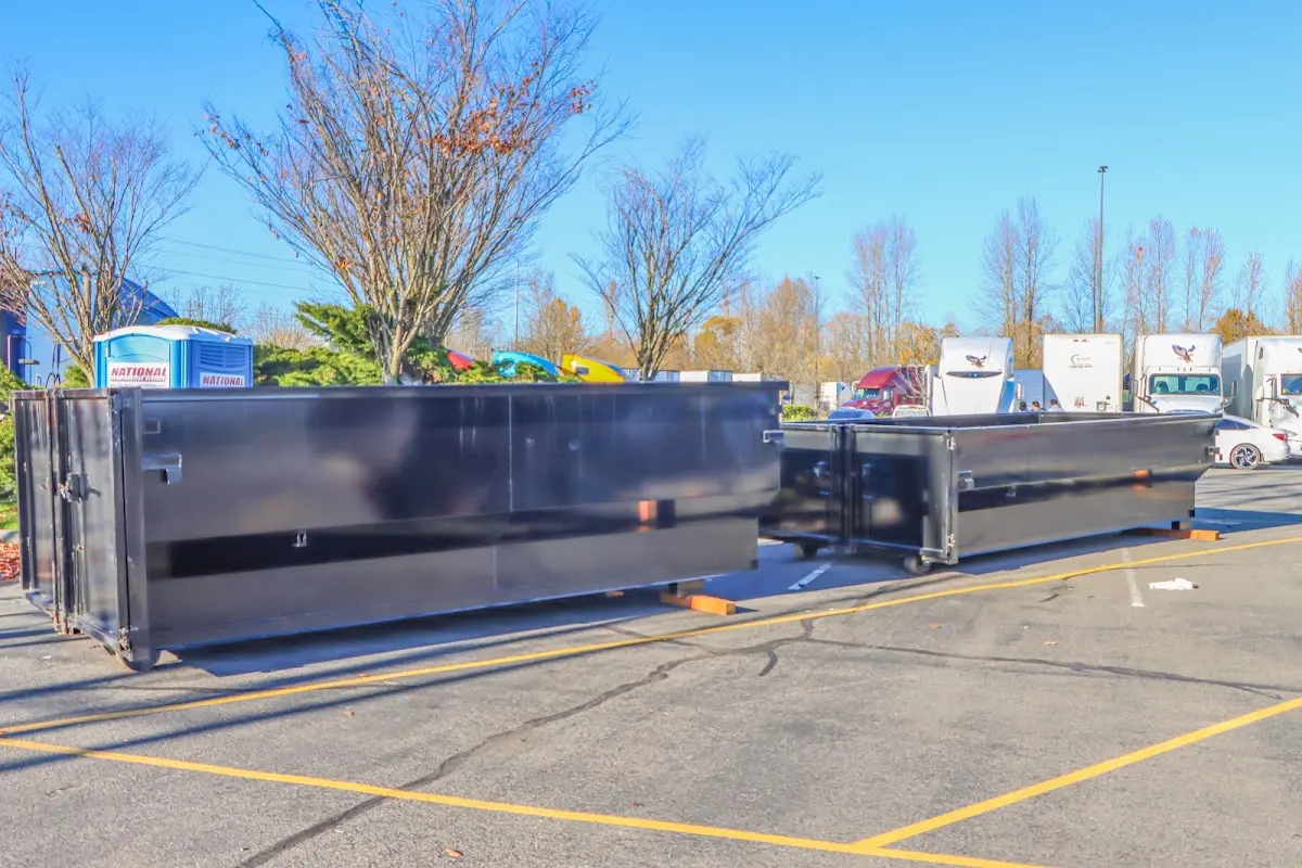 Professional dumpster rental service with roll-off container on residential driveway in Oxford